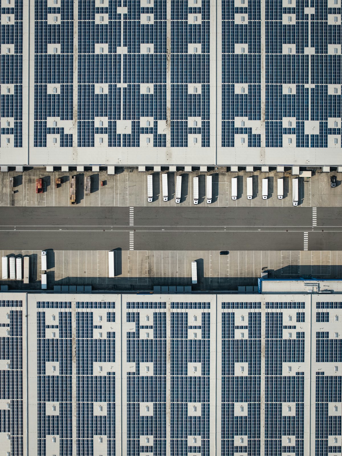 Tecnico con casco su una copertura industriale con pannelli fotovoltaici