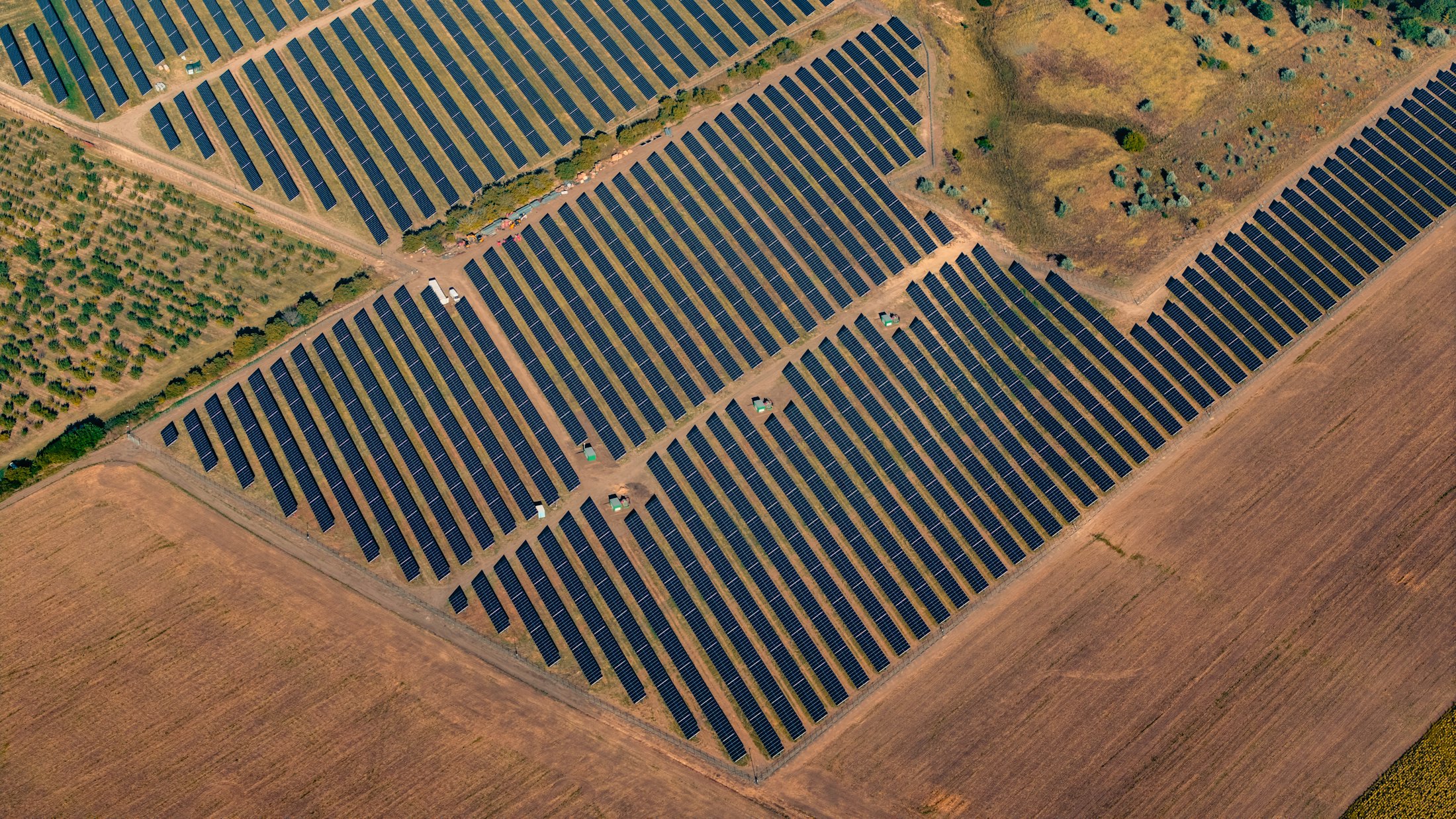 Parco fotovoltaico a terra tra campi coltivati, visto dall'alto